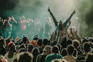 Energetic Crowd Enjoying A Live Performance At A Music Festival Wallpaper