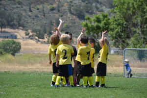Energetic Kids Playing A Game Of Soccer Wallpaper
