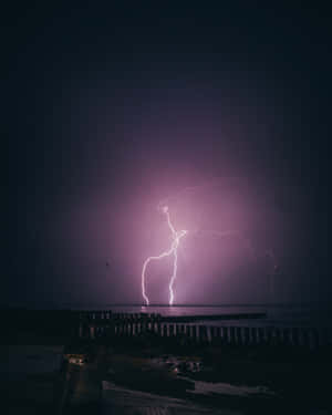 Energetic Purple Lightning Illuminating A Refreshing Night Wallpaper