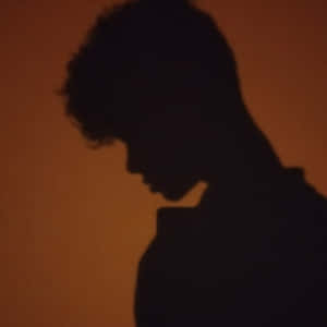 Enigmatic Curly-haired Figure In Shadow Pfp Wallpaper