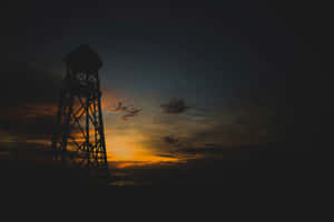 Enigmatic Dark Tower Against A Breathtaking Night Sky Wallpaper