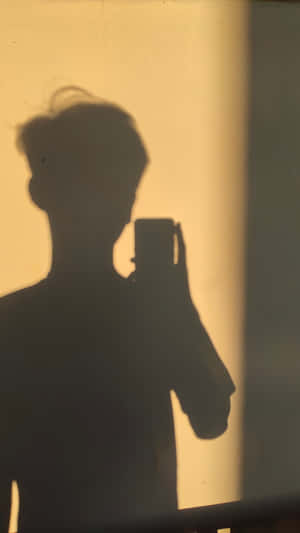 Enigmatic Teenage Boy Shadow Profile Picture Wallpaper