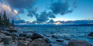 Enjoy An Enchanting View Of Lake Tahoe Reflecting The Setting Sun Wallpaper