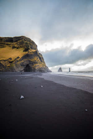 Enjoy The Beauty Of Nature At The Black Sand Beach Wallpaper
