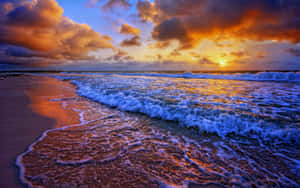 Enjoy The Gentle Colors Of A Sunset Wave. Wallpaper