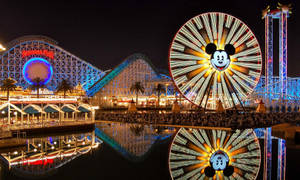 Enjoy The Magical View Of Pixar Pier At Night Wallpaper