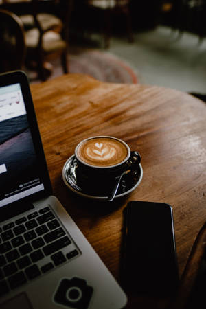 Enjoying A Delicious Cup Of Latte Art. Wallpaper