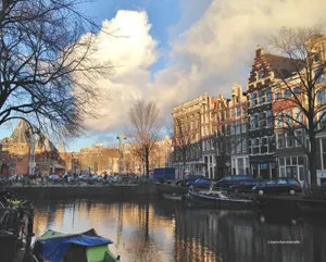 Enjoying A Sunny Spring Day By A Canal In Amsterdam Wallpaper