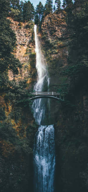 Enjoying The Magic Of A Beautiful Waterfall. Wallpaper