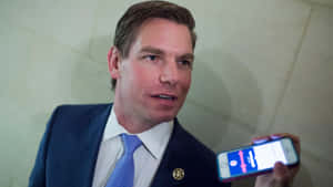 Eric Swalwell Holding Smartphone Wallpaper