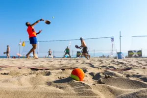 Exciting Beach Tennis Match At Sunset Wallpaper