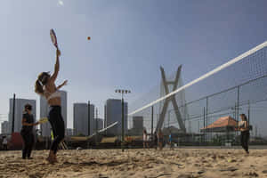 Exciting Game Of Beach Tennis In The Sun Wallpaper