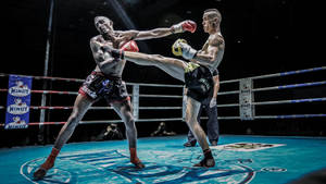 Exciting Moments Captured During An Intense Kickboxing Match Wallpaper