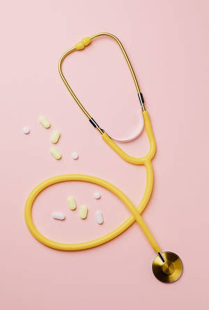 Experienced Doctor Wearing A Yellow Stethoscope Wallpaper