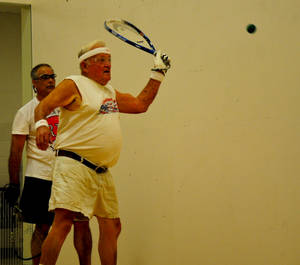 Experienced Senior Playing An Intense Game Of Racquetball Wallpaper