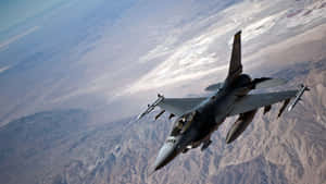 F16_ Fighter_ Jet_ In_ Flight_ Over_ Mountains Wallpaper