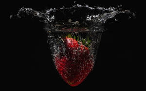 Falling Strawberry In Water Wallpaper