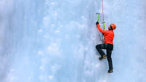 Fearless Adventurer Scaling A Majestic Mountain Wallpaper