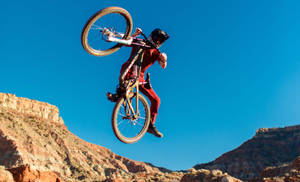 Fearless Biker Mastering A Challenging Mountain Trail In 4k Resolution. Wallpaper