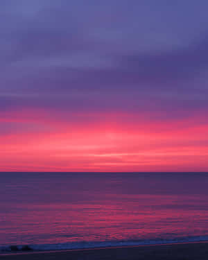 Feel The Warmth Of The Setting Sun On A Beautiful Pink Beach Wallpaper