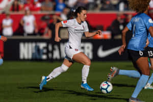 Female Soccer Player Dribbling During Match Wallpaper