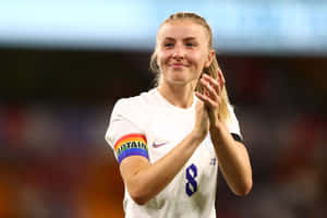 Female Soccer Player With Captain Armband Wallpaper