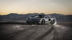 Ferocious Mclaren 600lt Cruising Down The Road Wallpaper
