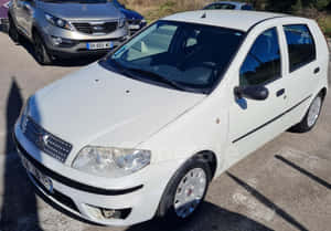 Fiat Punto Driving On City Street Wallpaper