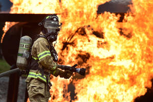 Firefighter On A Burning Plantation Wallpaper