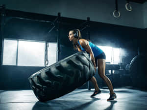 Fitness Enthusiast Flipping Tirein Gym.jpg Wallpaper