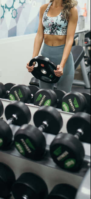 Fitness Enthusiast Selecting Dumbbell.jpg Wallpaper