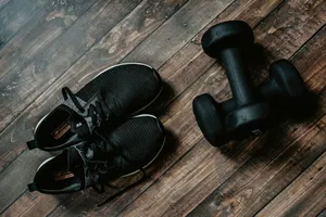 Fitness Ready Sneakersand Dumbbellson Wooden Floor Wallpaper