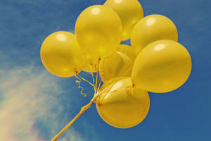 Flying Neon Yellow Balloons Wallpaper