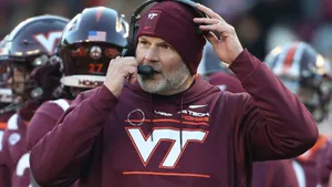 Focused Football Coach Studying The Game Wallpaper