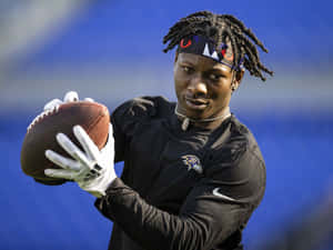 Focused Football Player Catching Ball Wallpaper