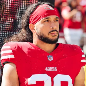 Focused Football Player Red Uniform Wallpaper