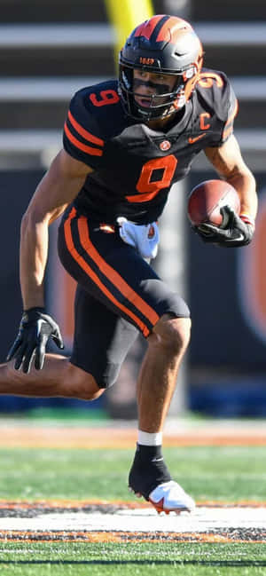 Focused Football Player Running With Ball Wallpaper