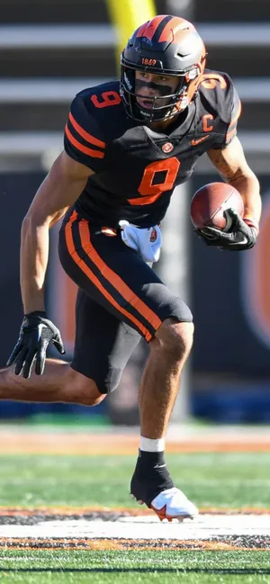Focused Football Player Running With Ball Wallpaper
