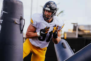 Focused Football Player Training Outdoors.jpg Wallpaper