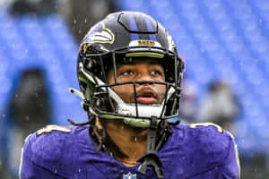 Focused Football Playerin Rain Wallpaper