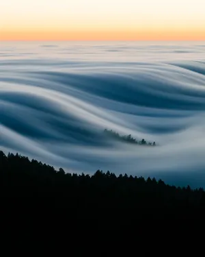 Fog Over A Mountain Range At Sunrise Wallpaper