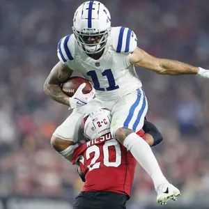 Football Athlete Evading Tackle Action Shot Wallpaper