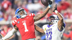 Football Athletes Competingfor Ball Wallpaper