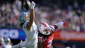 Football Defensive Leap Interception Attempt Wallpaper