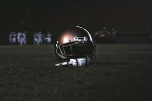 Football Helmeton Fieldat Night Wallpaper