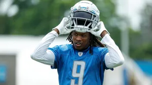 Football Player Adjusting Helmet During Practice Wallpaper