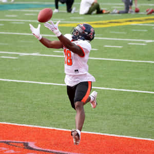 Football Player Catching Ball Action Shot Wallpaper