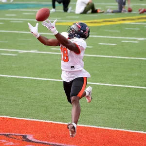 Football Player Catching Ball Action Shot Wallpaper