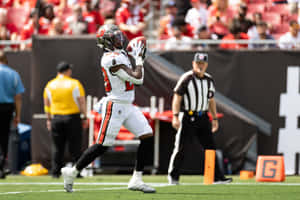 Football Player Catching Ball During Game Wallpaper