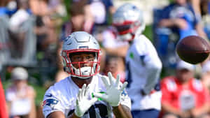 Football Player Catching Ball During Game Wallpaper